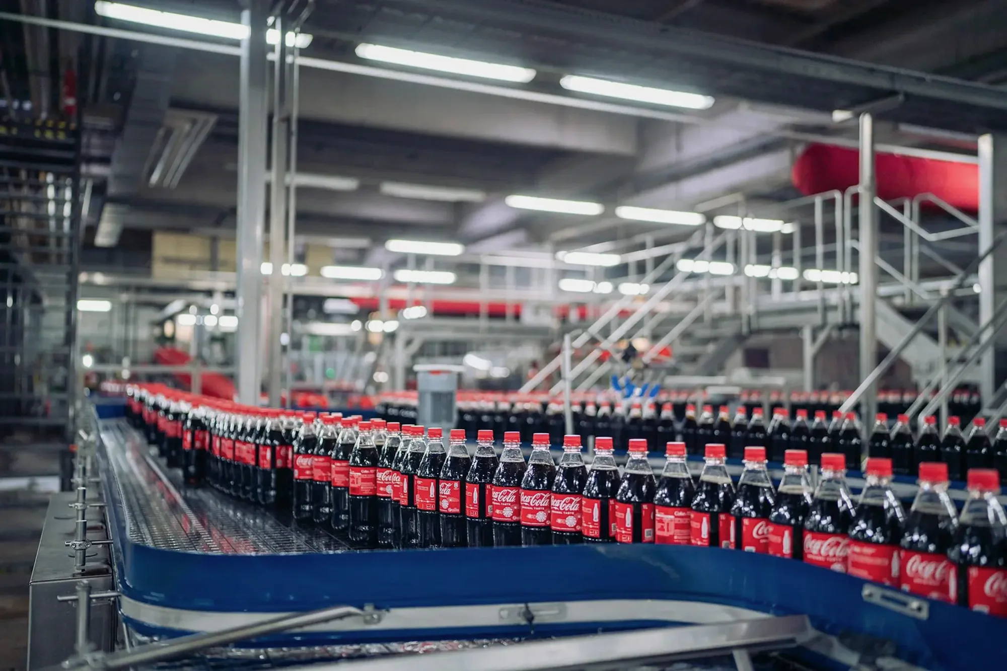Coca-Cola PET bottles moving through a high-speed carbonated soft drink bottling and conveying line