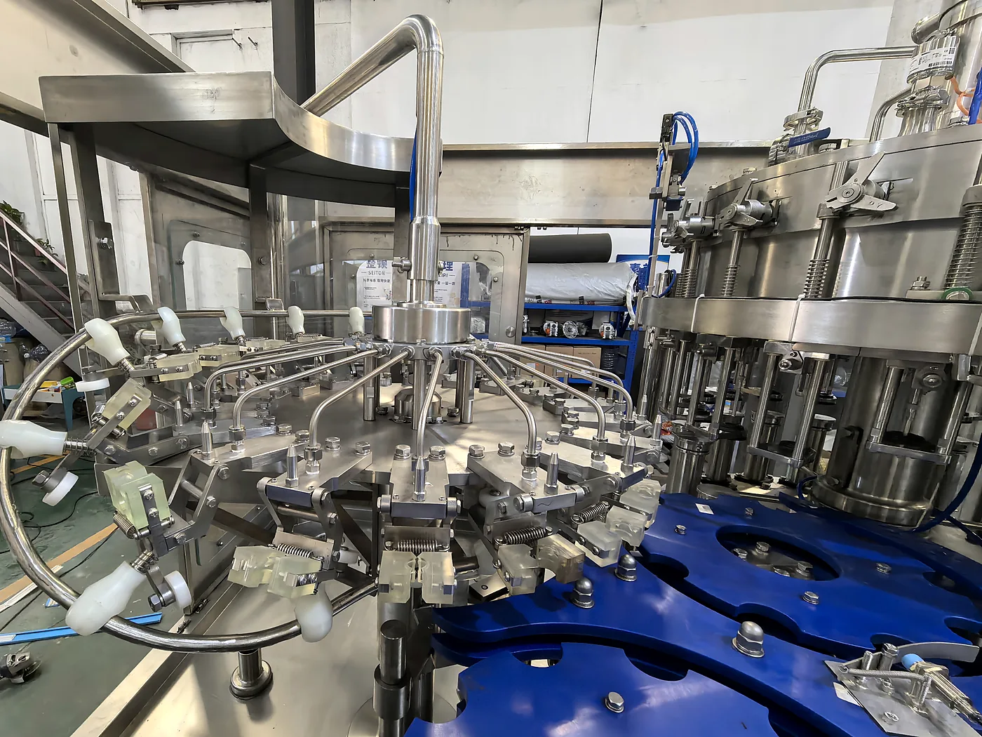 Glass bottle rinsing and transfer starwheel assembly with stainless-steel guides